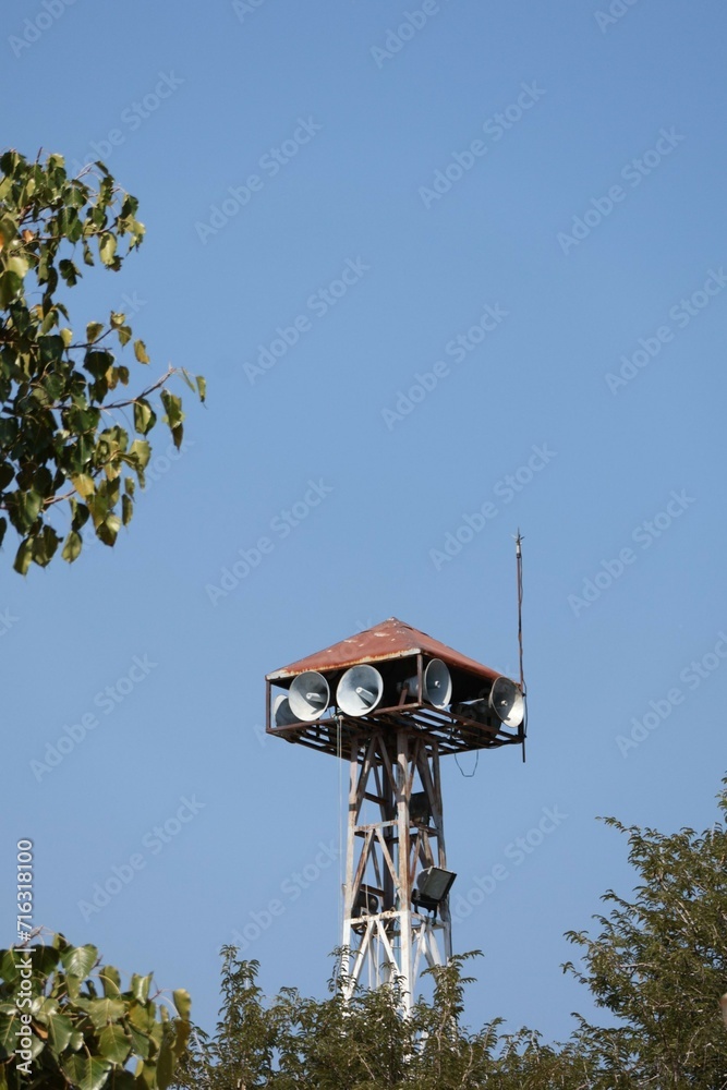 Village news speaker tower on blue sky background, horn speaker