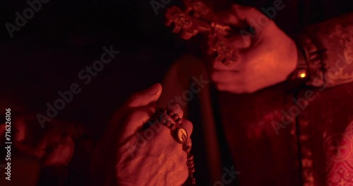 A church cross in the hands of a military chaplain. The footage was taken in a dark dugout during the confession of a Ukrainian soldier. photo