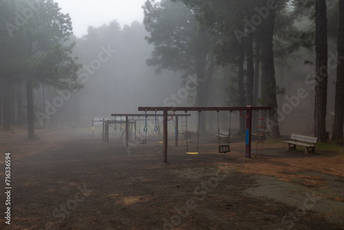 Empty swing on a playground in a foggy forest on the island of La Palma  Spain 