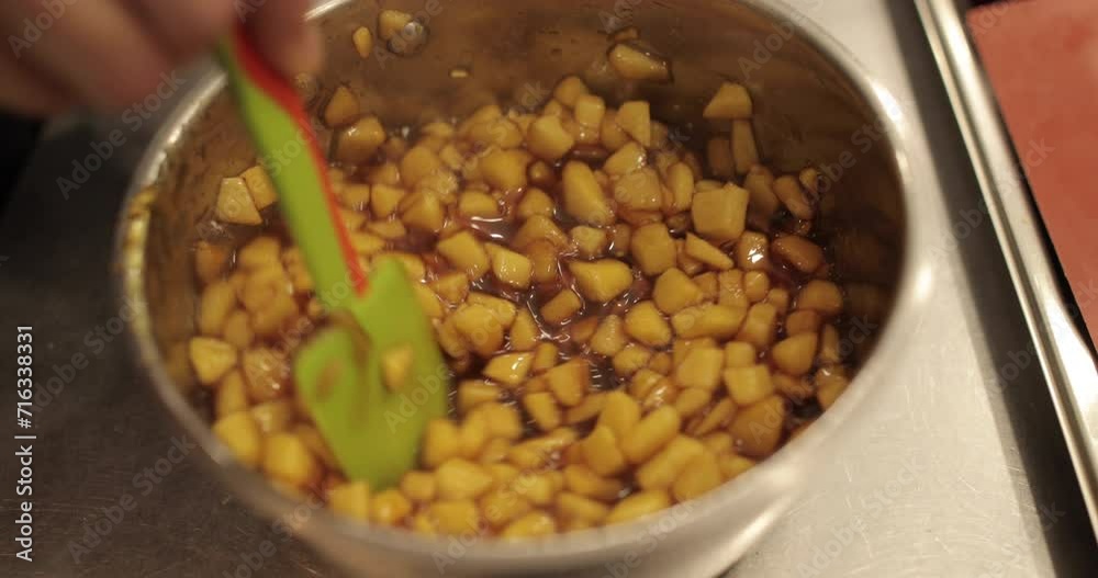 Preparation of apples for filling in confectionery. Mixing diced apples in a saucepan and stirring while heating. Filling for tartlets. Preparation of apples for filling in confectionery. Mixing diced apples in a saucepan and stirring while heating. Filling for tartlets.