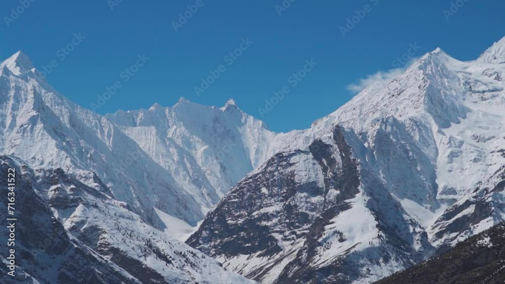 Landscape shot of snow covered Himalayan mountain peaks during the winter season as seen from Keylong at Lahaul Valley in Himachal Pradesh, India. Snowy mountain peaks during the winter season. Landscape shot of snow covered Himalayan mountain peaks during the winter season as seen from Keylong at Lahaul Valley in Himachal Pradesh, India. Snowy mountain peaks during the winter season.