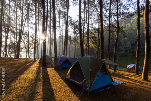 Group of tent for overnight camping with sunrise over the misty mountain and ray of light and campsite of Pang Oung, Mae Hong Son province, Thailand