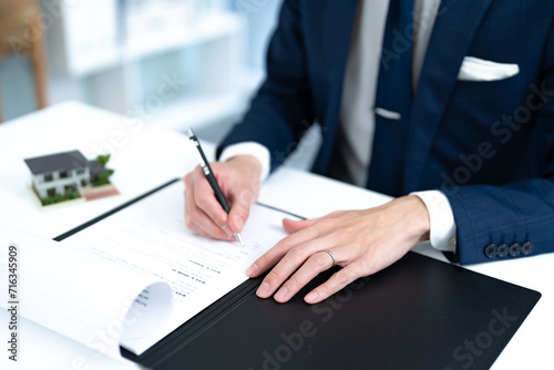 オフィスで書類を書くスーツを着た男性 photo