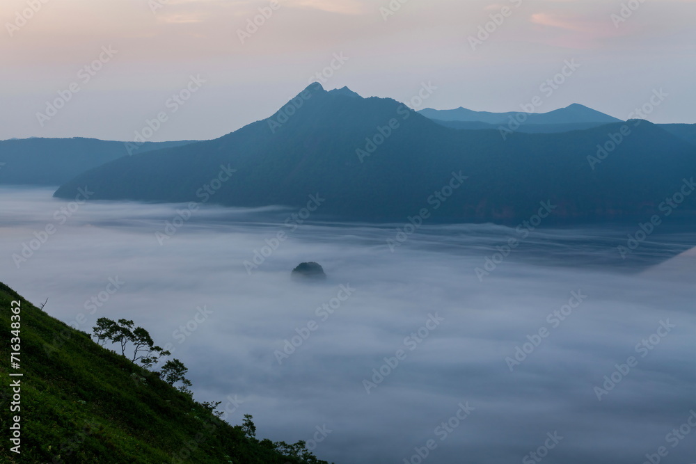 夜明け前の摩周湖の霧と対岸の山並み