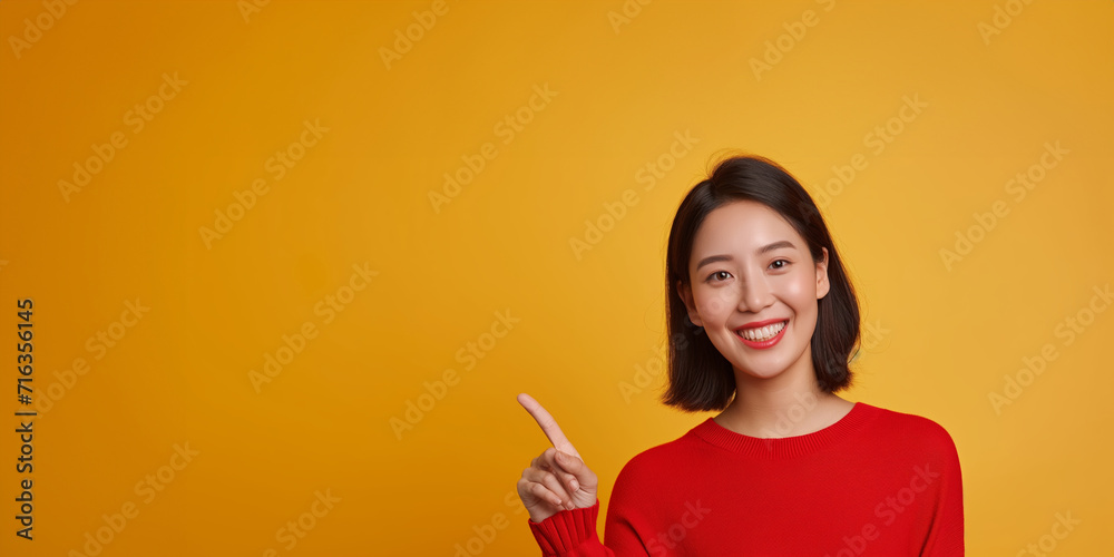 Asian woman presents, pointing with copy space yellow background, portrait captures the beauty, confidence, and elegance of a young and attractive Asian model. Asian Beauty Portrait A happy and fashio Asian woman presents, pointing with copy space yellow background, portrait captures the beauty, confidence, and elegance of a young and attractive Asian model. Asian Beauty Portrait A happy and fashio