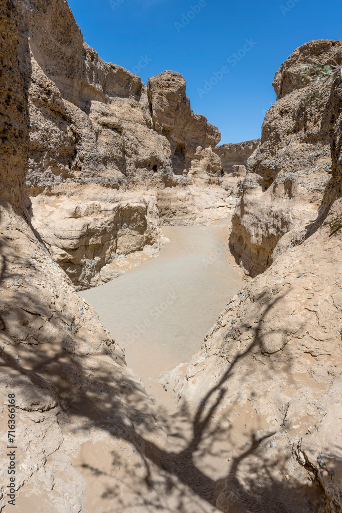 dry riverbed and worn sandstone cliffs at narrow Serisem canyon, Naukluft desert,  Namibia