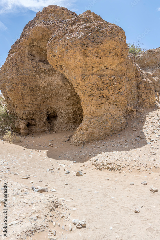 worn sandstone boulder on sand dry riverbed at narrow Serisem canyon, Naukluft desert,  Namibia