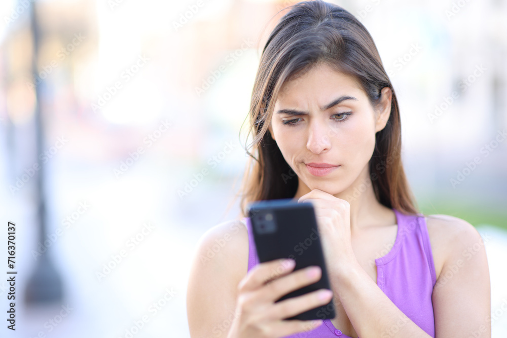 Suspicious woman checks phone in the street Suspicious woman checks phone in the street
