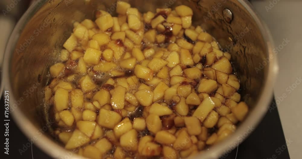 Preparation of apples for filling in confectionery. Mixing diced apples in a saucepan and stirring while heating. Filling for tartlets. Preparation of apples for filling in confectionery. Mixing diced apples in a saucepan and stirring while heating. Filling for tartlets.