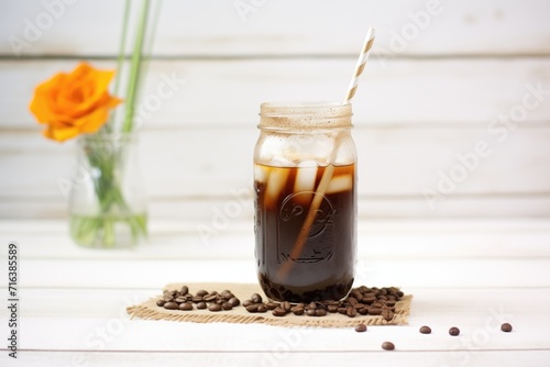 cold brew in mason jar with straw, on burlap