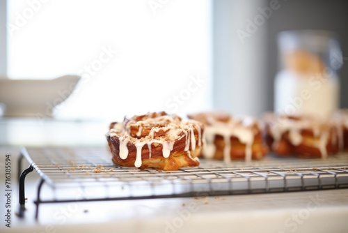 fresh cinnamon rolls with icing on a wire rack photo