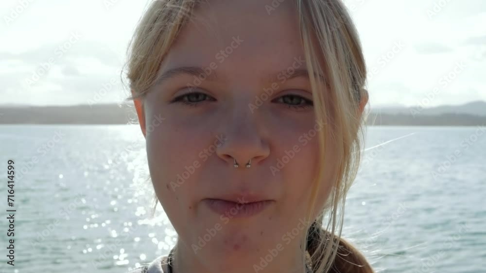Young beautiful girl chews gum outdoors against the background of the sea. High quality FullHD footage