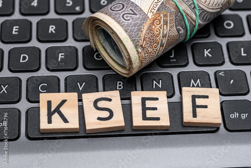 KSEF napis na klawiaturze komputera, krajowy system e-faktur napis leży na laptopie obok polskich pieniędzy 