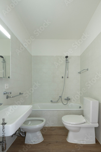 Front view of a bathroom with toilet  washbasin  bidet and bathtub