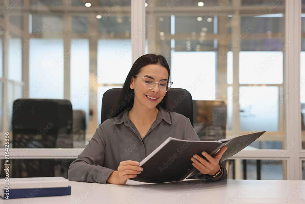Smiling woman working at table in office. Lawyer, businesswoman, accountant or manager Smiling woman working at table in office. Lawyer, businesswoman, accountant or manager