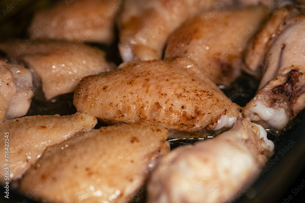 Baked chicken wings in spices close-up. Cooking healthy food at home