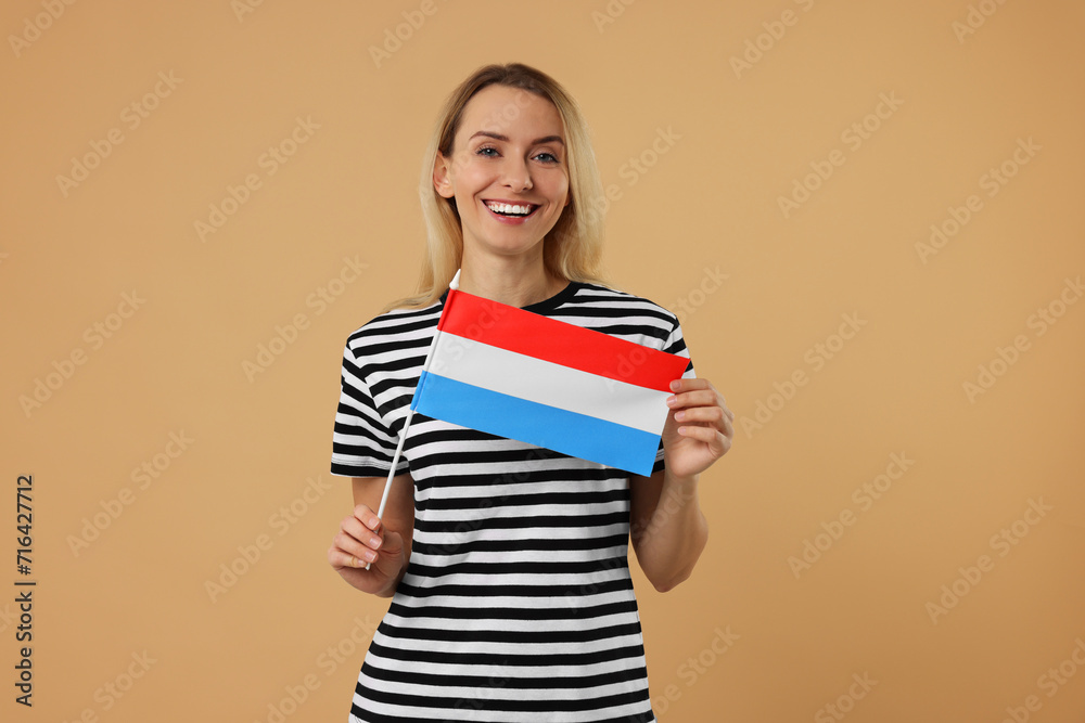 Happy woman with flag of Netherlands on beige background Happy woman with flag of Netherlands on beige background