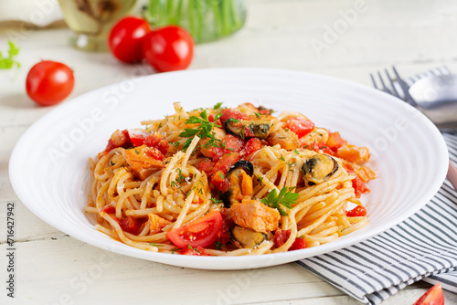 Classic italian pasta spaghetti marinara with mussels and salmon on white table. Spaghetti pasta with sauce marinara.