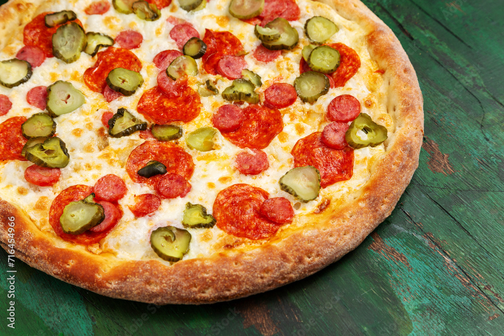 Pizza with cheese, salami and cucumber. Close-up.