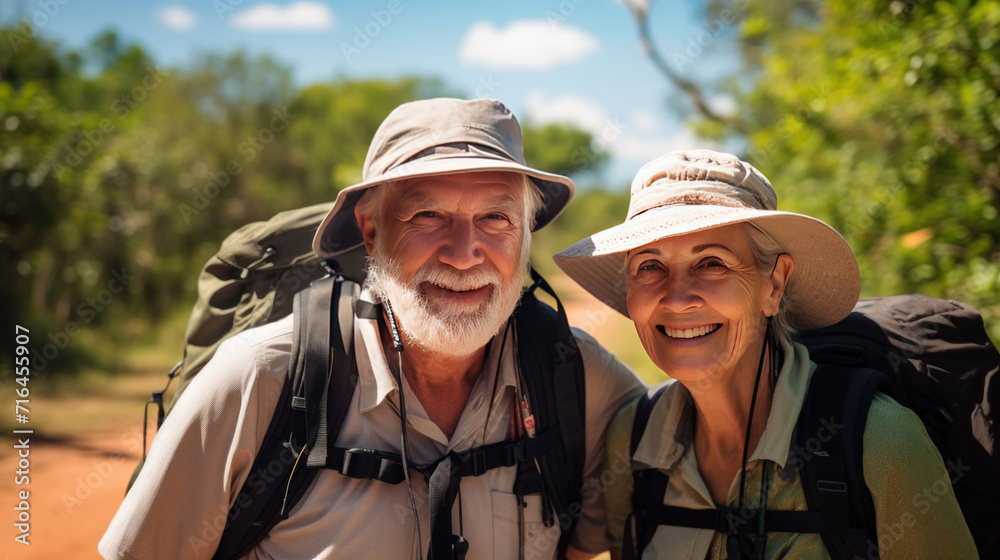A happy senior couple tourists and travellers hiking in nature.