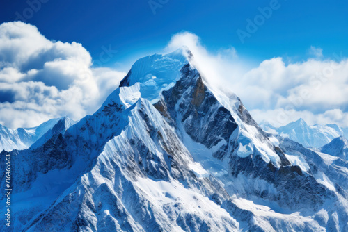 A majestic snowy mountain peak towering above the clouds  its pristine white slopes contrasting against the deep blue sky.