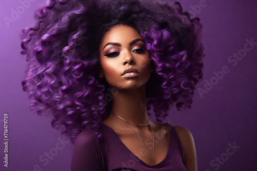 Beautiful african american woman with afro hairstyle and makeup on purple background photo