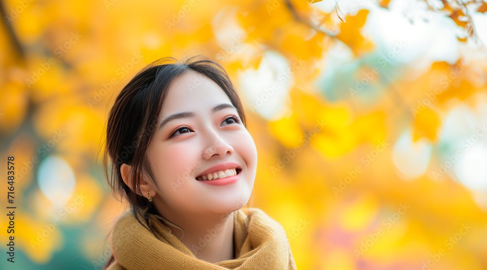 Portrait of happy and smiling young Chinese woman in autumn park, positive and cheerful young woman enjoying walk outdoors in ginkgo biloba forest in autumn Portrait of happy and smiling young Chinese woman in autumn park, positive and cheerful young woman enjoying walk outdoors in ginkgo biloba forest in autumn