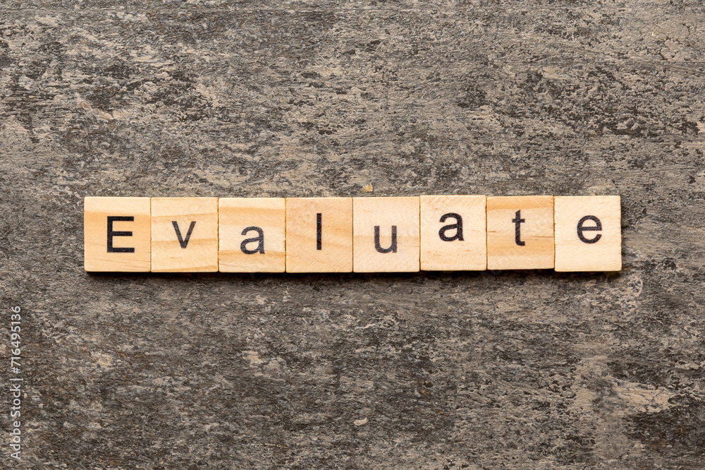 Fototapeta premium EVALUATE word written on wood block. EVALUATE text on cement table for your desing, concept