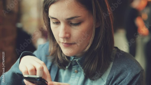 Face, phone and social media with woman in coffee shop closeup for communication or networking. Contact, app and text message with young customer scrolling in cafe or restaurant for online browsing photo
