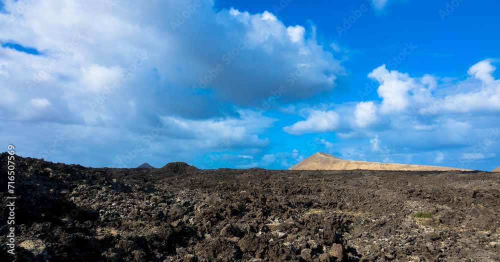 Spectacular view of the Fire Mountains at Timanfaya National Park, this unique area consisting entirely of volcanic soils. Volcanic landscape in a sea of ​​lava. Plenty space of text. Lanzarote, Spain