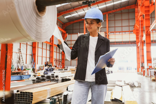 Female inspection engineer inspects the quality of plastic rolls, galvanized sheets, metal sheets in an industrial factory with confidence, trusting the quality of the materials during production. photo