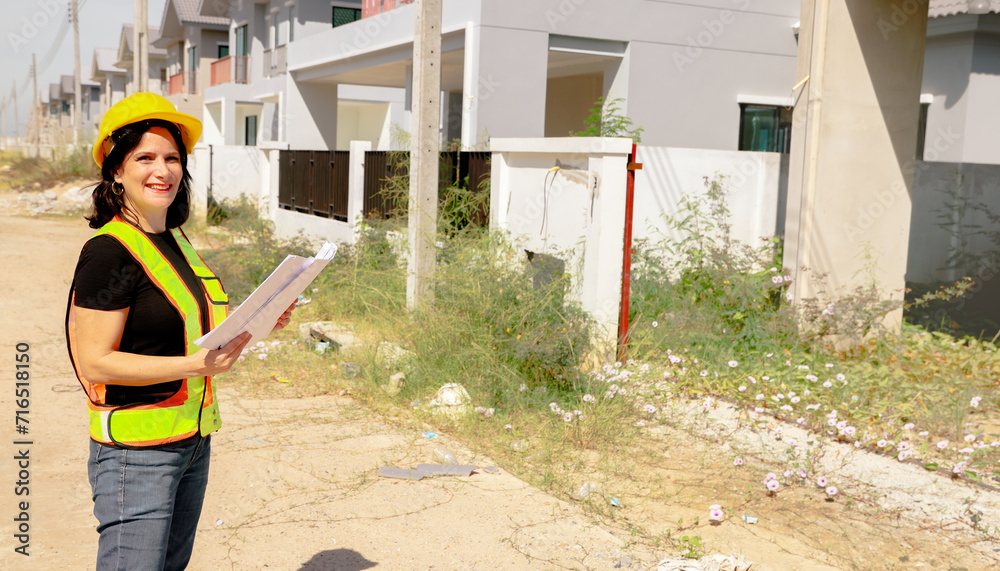custom made wallpaper toronto digitalSenior female architect holds blueprint housing project stands at the construction site in front of the project looks at the progress inspects the site under construction with confidence in success.