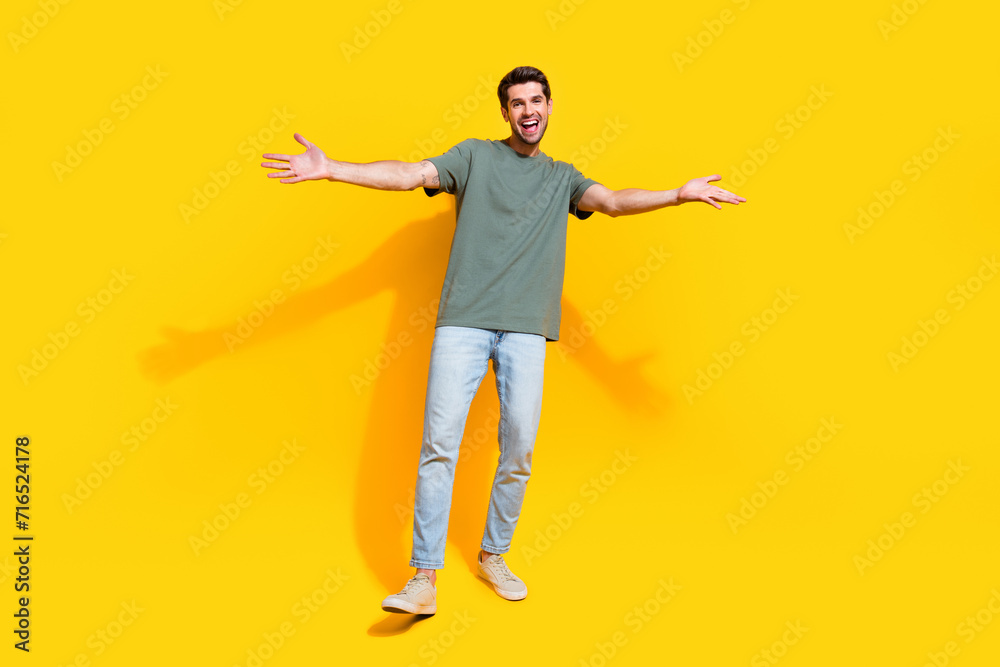 Full length photo of cheerful positive man dressed khaki t-shirt open arms missing you isolated yellow color background - obrazy, fototapety, plakaty 