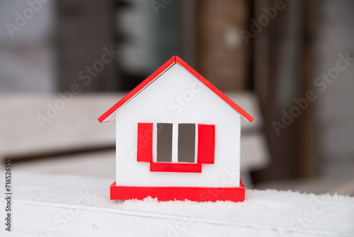 house in winter - heating system concept and cold snowy weather with model of a house wearing a knitted cap. High quality photo