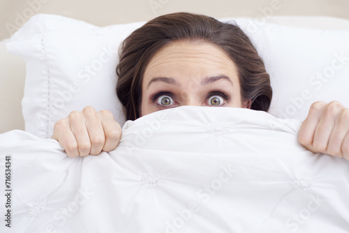 Morning, face of shocked woman in bed and blanket to wake up, relax and getting ready to start day. Pillow, portrait and girl in bedroom with rest, wellness and comfort in hotel, home or apartment.