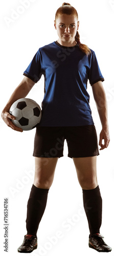 Full-length of young woman, football player in blue uniform standing with ball isolated over transparent background. Concept of sport, competition, action, winner, tournament, active lifestyle