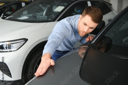 Man adult customer male buyer client chooses auto wants to buy new automobile