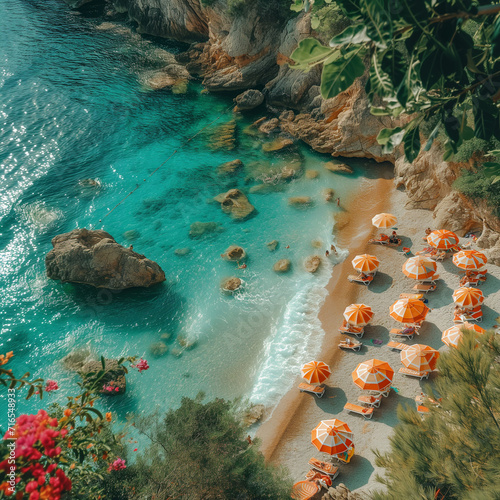 Aerial view of a tourist cove with umbrellas and sunbathers at sunrise