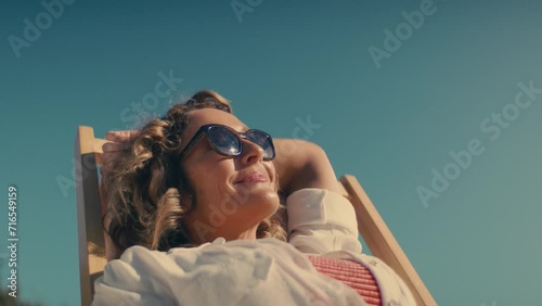 Beautiful middle-aged woman smiling and sunbathing photo