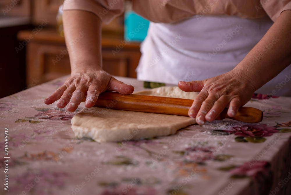 Cook's hands kneading dough for cakes. Preparing the flour for leavening