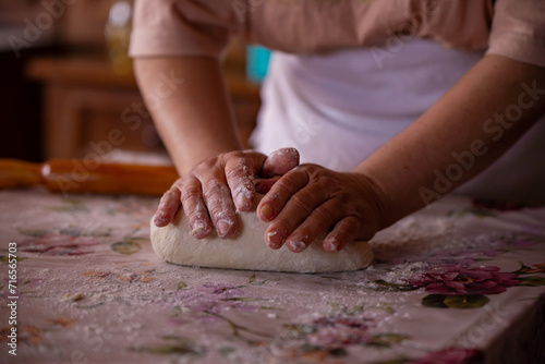 Cook's hands kneading dough for cakes. Preparing the flour for leavening photo