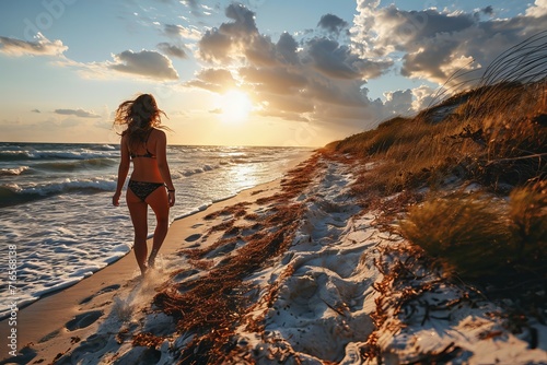 A slender woman enters the water among the raging waves. Concept: a girl on a beach holiday, walking along the water. Tourist destinations to the sea. Banner with copy space