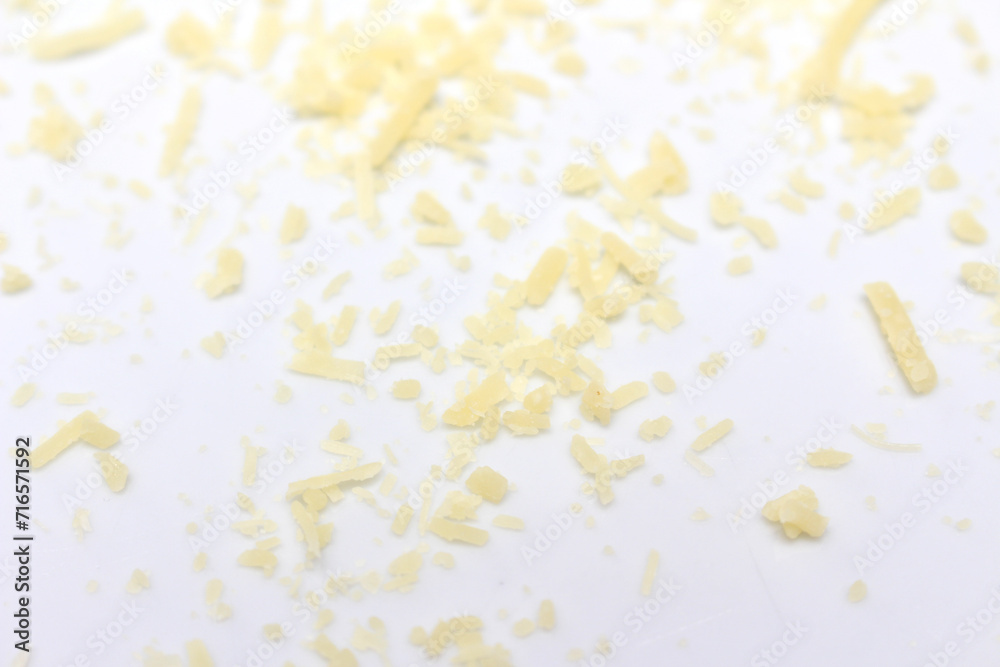 grated cheese on white plate. cheese with selective focus. small pieces of cheese.