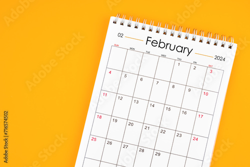 February 2024 desk calendar on yellow color background, position with copy space. © gamjai
