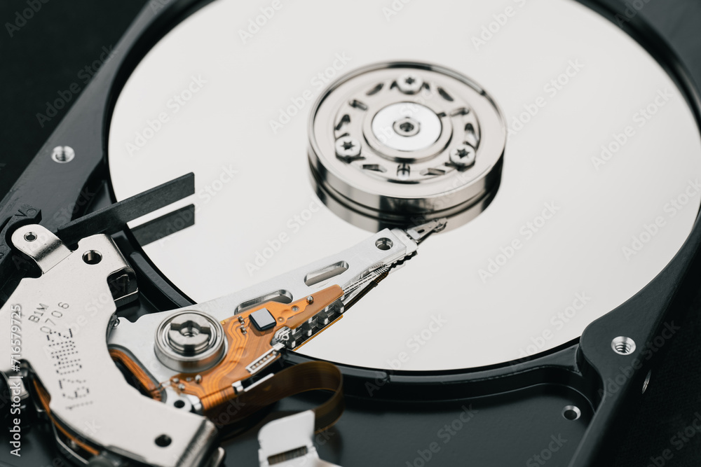 Hard drive isolated on white background. HDD. Major components of a 3.5-inch SATA hard disk drive: platter, spindle, actuator, actuator arm. Disk head above the plates Hard drive isolated on white background. HDD. Major components of a 3.5-inch SATA hard disk drive: platter, spindle, actuator, actuator arm. Disk head above the plates