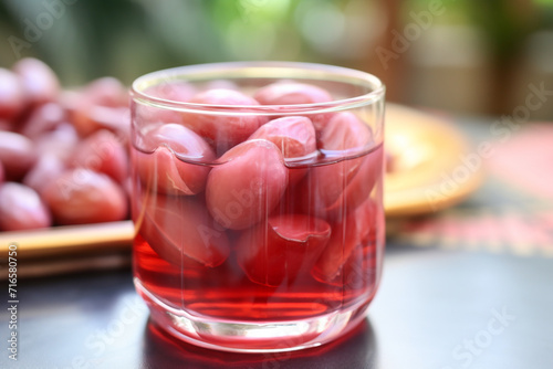 Selective focus or close up of manisan kolang kaling or preserved palm fruit, pink red, served in a glass. Indonesian special desserts during Ramadan and on Eid al-Fitr or Hari Raya