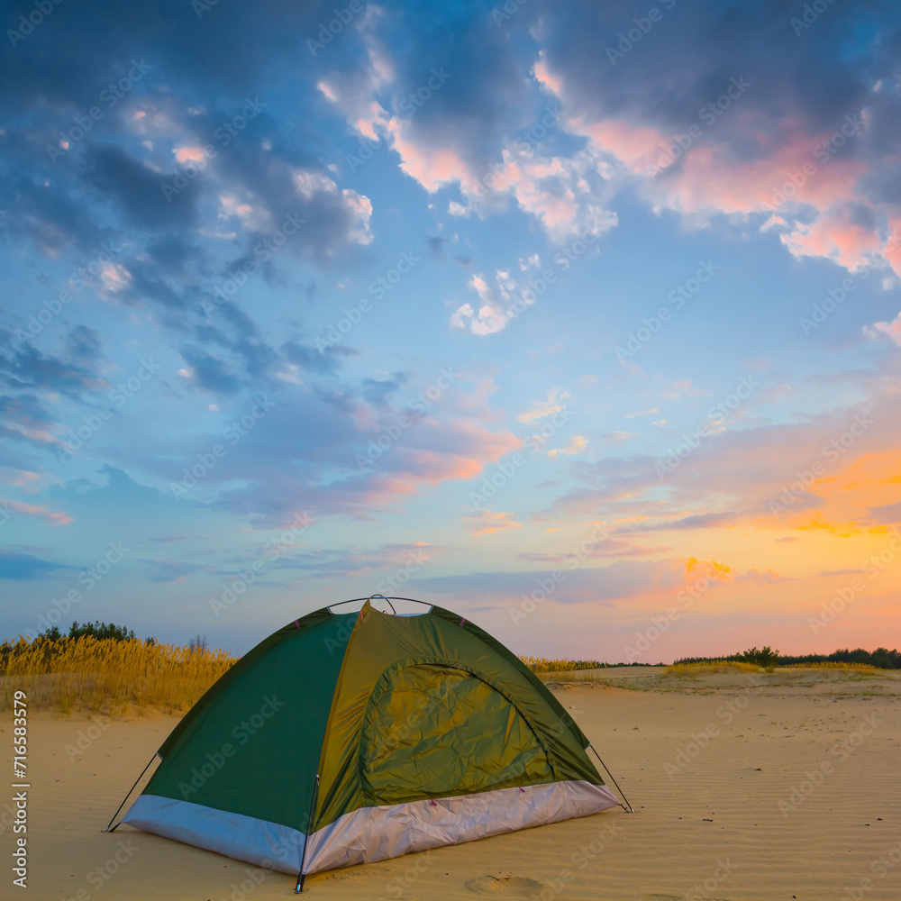 closeup small touristic tent among sandy desert at the evening