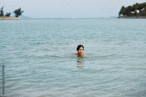 Swim and Smile: An Active Asian Man's Tropical Beach Adventure © SHOTPRIME STUDIO