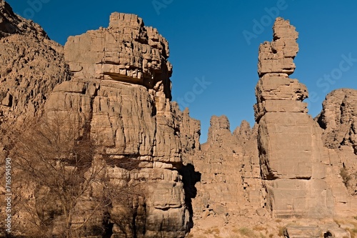 Rock formations at Guelta Tikoubaouine in the tourist area of Immourouden, near the town of Djanet. Tassili n Ajjer National Park. Sahara desert. Algeria. Africa. photo