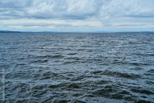 Blue water in ocean or sea with coastline on horizon